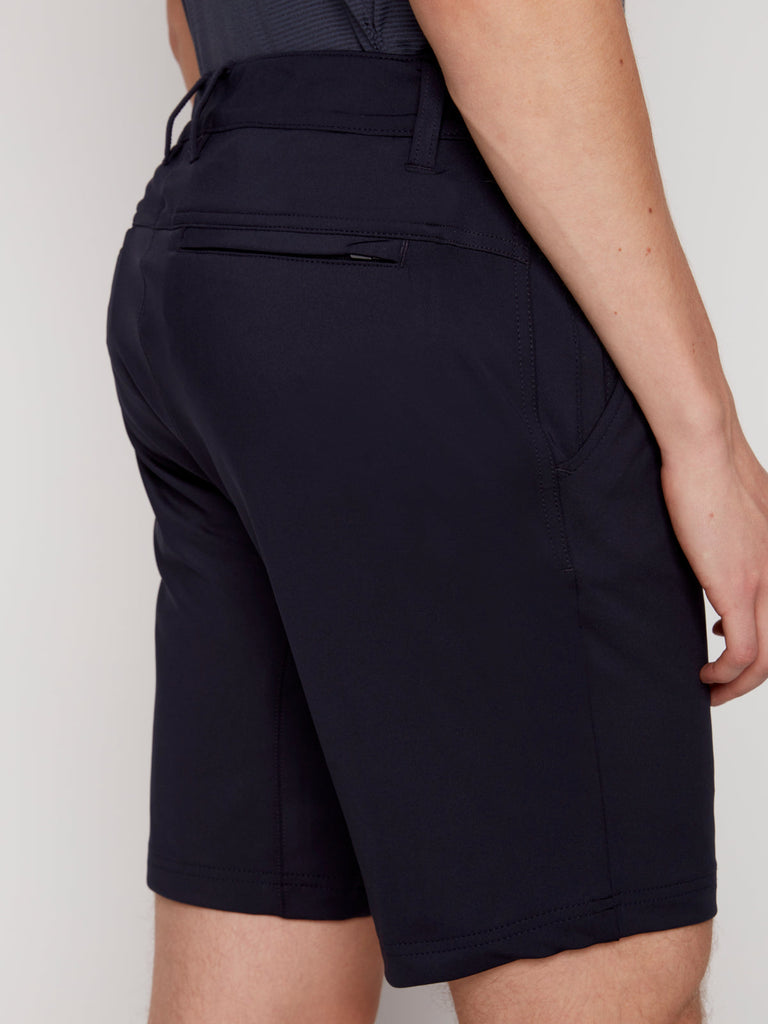 A person is shown from the back wearing Projek Raw DAMIAN MENS SHORT - NAVY, featuring a zipped back pocket and a tucked-in shirt, with their right arm relaxed at their side.