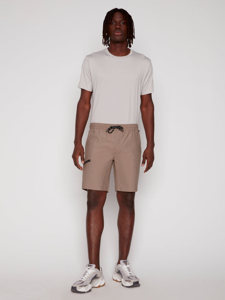 A man wearing Projek Raw LUKA MENS SHORTS in beige.