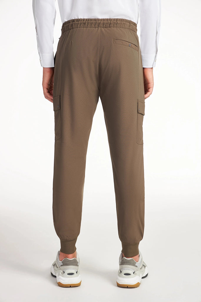 A man is shown from the back wearing TECH APPAREL MENS FLUX 2.0 CARGO JOGGER pants with side pockets and white sneakers, set against a plain white background.