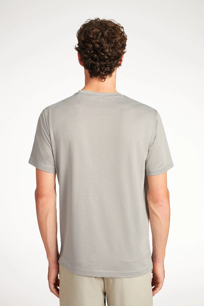A person with short curly hair stands with their back to the camera, wearing the TECH APPAREL MENS VARIEGATED STRIPE CREWNECK T-SHIRT and light-colored shorts against a plain white background.