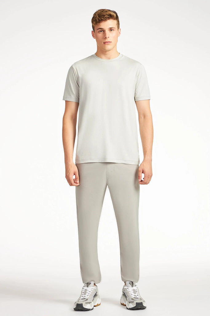 A young man faces forward, wearing the TECH APPAREL MENS BRUSHED SPACE DYED T-SHIRT with matching joggers and white sneakers, standing against a plain white background.