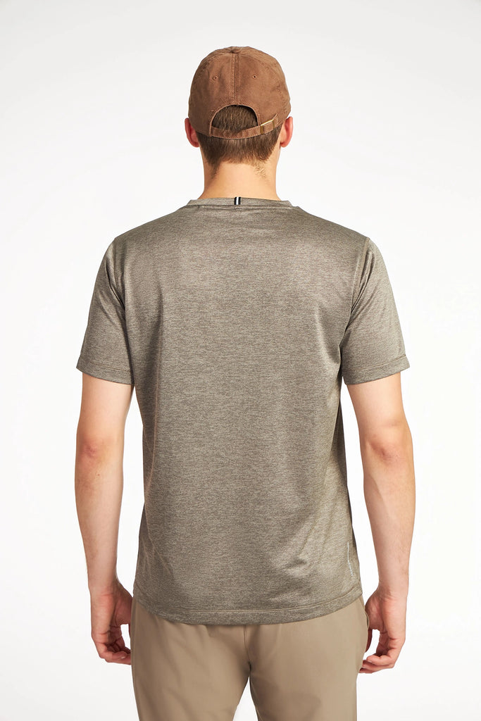 A person in a brown cap, beige pants, and a gray TECH APPAREL MENS MARLED PIQUEE T-SHIRT stands facing away from the camera against a plain white background.