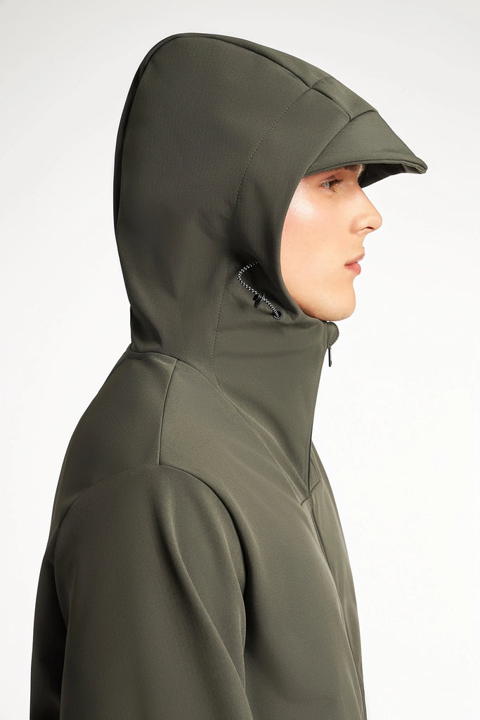 A person in profile wears the olive green TECH APPAREL MENS BONDED FLEECE JACKET with the hood up, showing its structured, weather-resistant design against a plain light background.