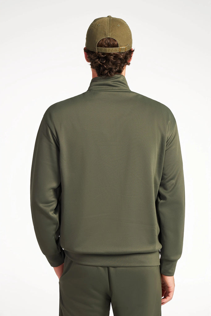 A person is shown from the back against a plain white background, wearing an olive green TECH APPAREL MENS NEO-KNIT ZIP-UP MOCK NECK SWEATER, matching pants, and a cap.